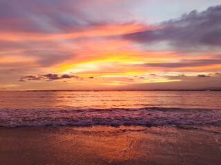 Fototapeta na wymiar Stunning Sunset Beach Scene with Fiery Red-Orange Sky Over a Tranquil Tropical Sea 