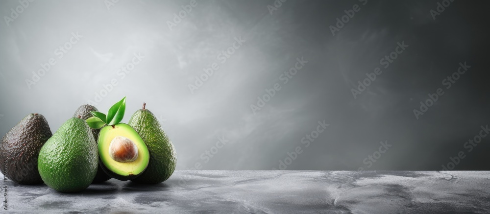 Poster a copy space image of mature avocados resting on a sleek grey textured surface