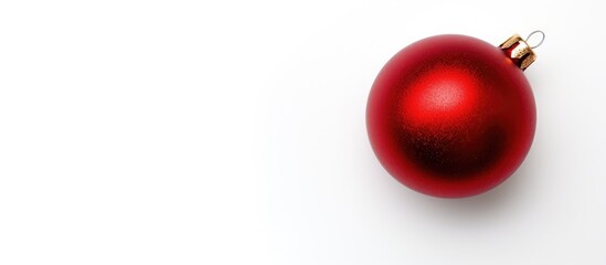 A red Christmas decoration is displayed on a white background in a flat lay copy space image