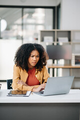 Young woman work late from home in room at late night overtime.Businesswoman bending over workplace while looking at laptop computer.