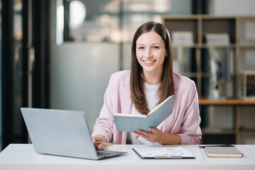 Woman reading book while sitting at  in cafe or office