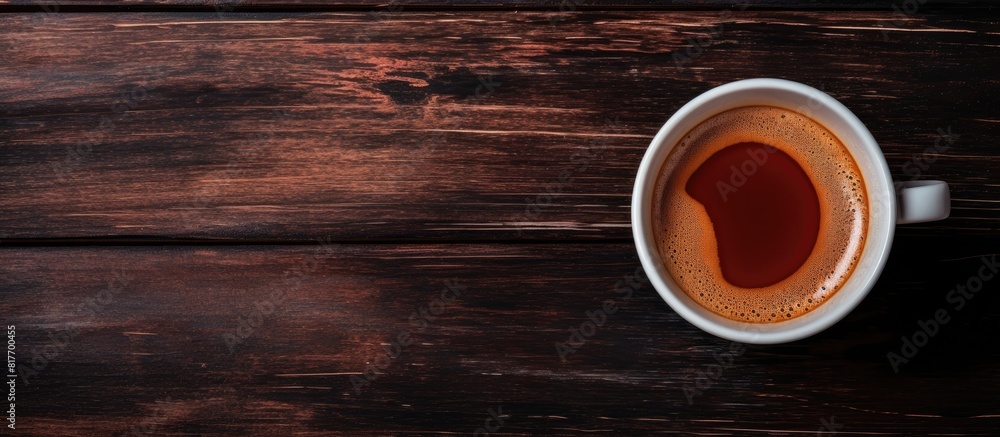 Poster a top down view of a cup of espresso coffee placed on a dark wooden backdrop providing ample space f