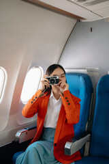 Asian woman sitting in a seat in airplane and looking out the window going on a trip vacation...