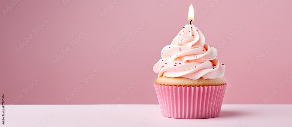 Poster a birthday cupcake with buttercream icing and a candle set against a pink pastel background there is