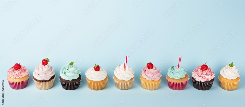 Poster a flat lay composition featuring cupcakes on a light blue background with room for text perfect for 