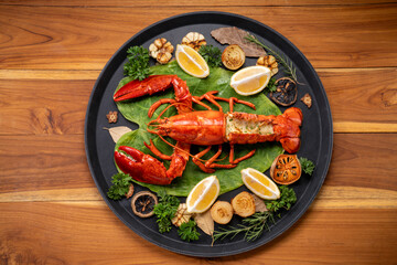 Grilled Lobster with Cheese in black wood plate, Grilled Canadian Lobster on wooden background.