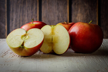 Four Polish red apples on a rustic background