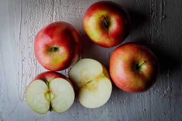 Four Polish red apples on a rustic background