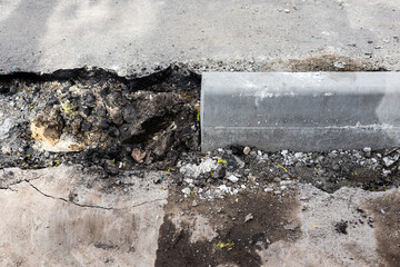 laying curb stones on a sidewalk in the city.