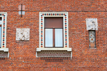 detailed view of a brick building facade showcasing historical sculptures and decorative patterns