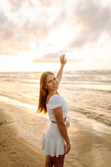 Young woman enjoying looking view of beach ocean on summer day at sunset. Travel, weekend, relax and lifestyle concept. 