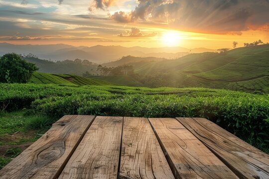 Empty wooden table in front of sunset tea plantation view