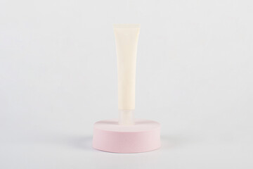 Cosmetic product in tube splashes with stylish props on white background. Shampoo, gel, balm white packaging
