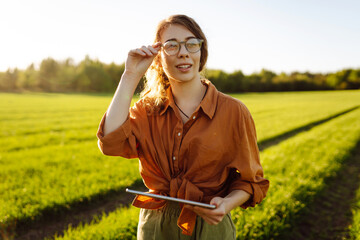 Woman Farmer  with tablet analysing  and control of plant quality in the soil smart digital...