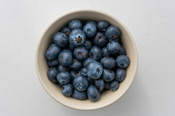 Top view of blueberries in a bowl on the marble surface