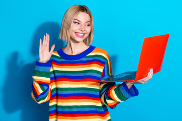 Photo portrait of pretty young girl work netbook video call wave hand wear trendy striped outfit isolated on blue color background