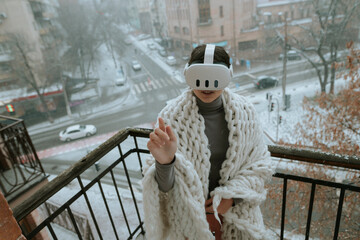Winter vistas surround a girl experiencing VR on the balcony with a headset.