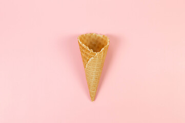 Top view of ice cream waffle cone on pink background. Summer wallpaper, flat lay, copy space.