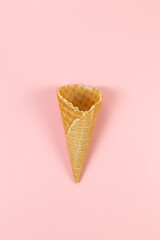 Top view of ice cream waffle cone on pink background. Summer wallpaper, flat lay, copy space.