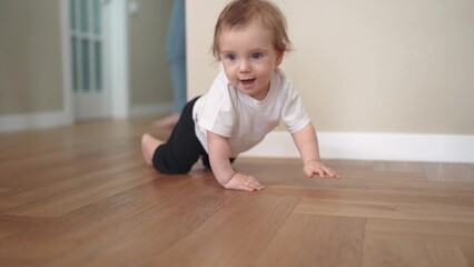 newborn baby crawls. happy family a kindergarten concept. First steps, crawling baby, view from the...