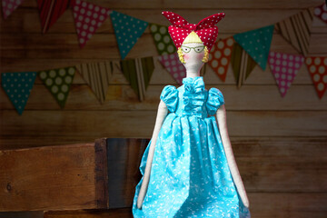 Handmade lady tilda doll in light blue dress with a red scarf on his head. Interior fairy doll