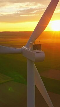 Alternative energy. Aerial view of windmills farm. Power energy production in USA. Landscape with wind turbines. Large wind turbines with blades in field aerial view bright orange sunset