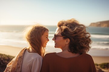  a happy 40 year old woman, 10 year old girl looking out to sea