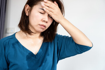 sweating asian woman feeling dizzy and fainting because of hot weather in summer