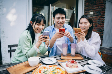 A group of young Asians is having a blast outdoors, laughing, chatting, and enjoying various activities together.