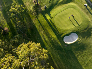 an aerial view of a green course with trees around it