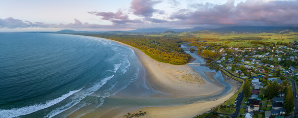an aerial view of a beach and water and sand with houses in it
