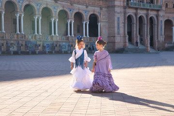 Two girls dancing flamenco walking and talking happily, with typical flamenco dress in a nice...
