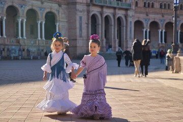 Two girls dancing flamenco walking and talking happily, with typical flamenco dress in a nice...