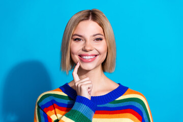 Fototapeta premium Portrait of pretty young girl finger touch chin wear striped pullover isolated on blue color background