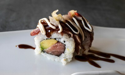 Closeup of an appetizing sushi roll with a drizzling of sauce