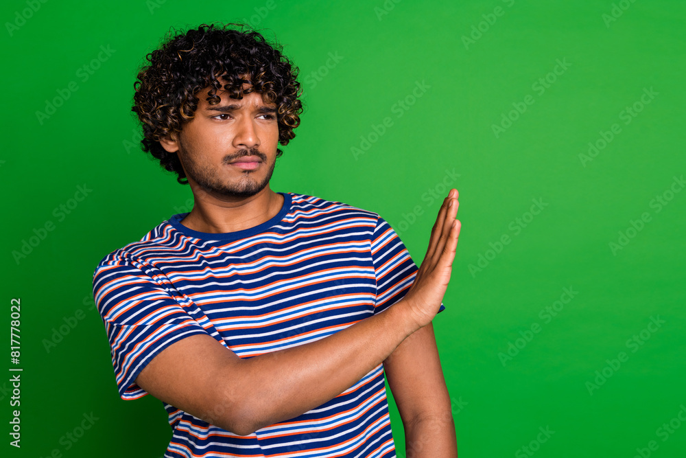 Poster Photo of confident serious sad man wear trendy striped clothes avoid empty space isolated on green color background