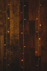 Vertical of decorative lights against a wooden wall at a wedding