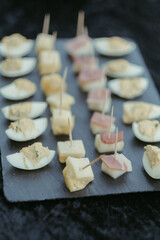 the black slate plate holds mini appetizers on a table