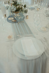 a table has plates and glasses on it with flowers in vases