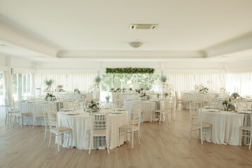 a banquet room with tables and white decorations and chairs set for dinner