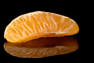 Ripe orange against a dark background, its bright hue contrasting with the darkness