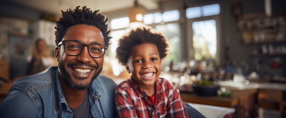 Portrait of father and son. African american middle age male with boy, smiling and happy sitting indoor. Father's Day concept. - Powered by Adobe