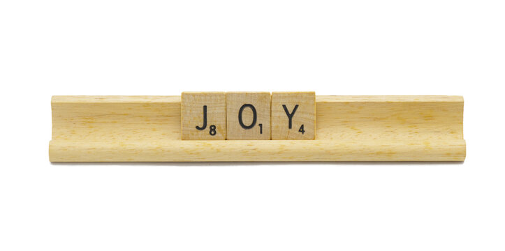 Miami, Florida 5-1-2024 JOY made with square wooden tile English alphabet letters with natural color and grain on a wood rack holder isolated on white background