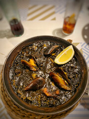 Top view of a negro paella rice dish on table