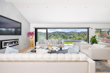 Elegant white sofa in a modern living room, illuminated by natural light from a nearby window