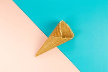 Top view of ice cream waffle cone on colorful background. Summer wallpaper, flat lay, copy space.