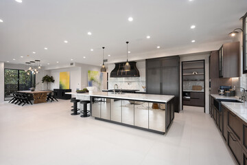 Bright and airy kitchen is illuminated by multiple overhead lights, creating a warm atmosphere