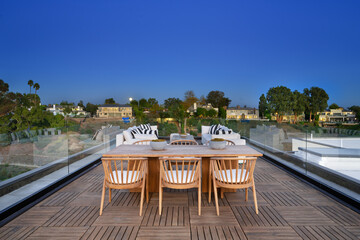Image is of a group of friends enjoying an evening together in an outdoor lounge area