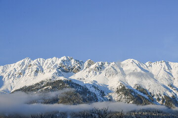 Fototapeta premium The mountains of the Nordkette surround Innsbruck in Tyrol with the summit Hafelekar