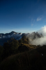 Misty mountains at dusk with a clear blue sky